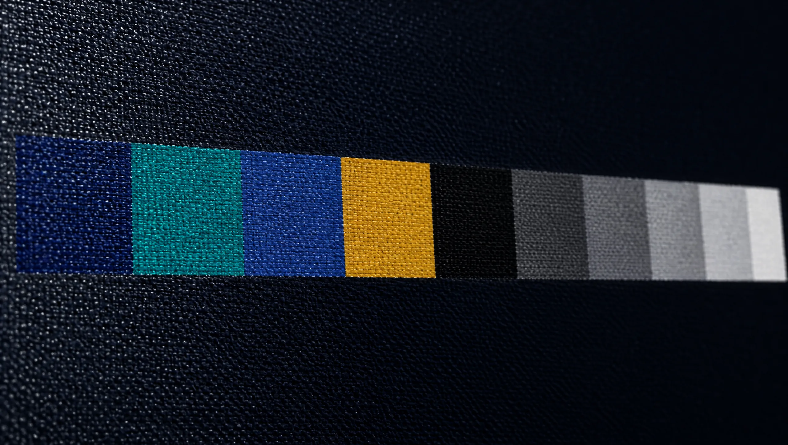 Printed color calibration patches on canvas in navy, teal, blue, gold and grays